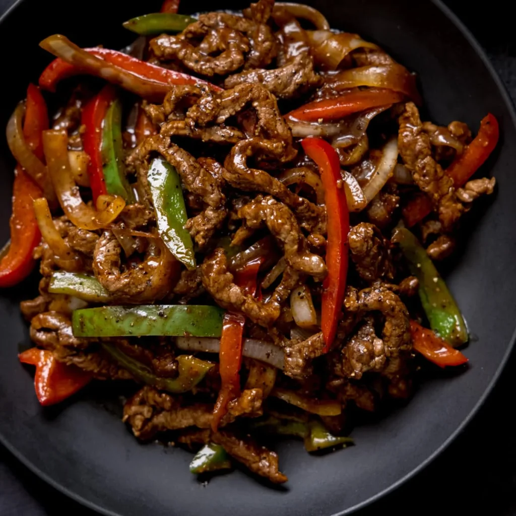 Black pepper beef or lamb, a savory Burmese dish with tender meat in a rich black pepper sauce, served at The Experience Burma, an authentic Burmese restaurant.